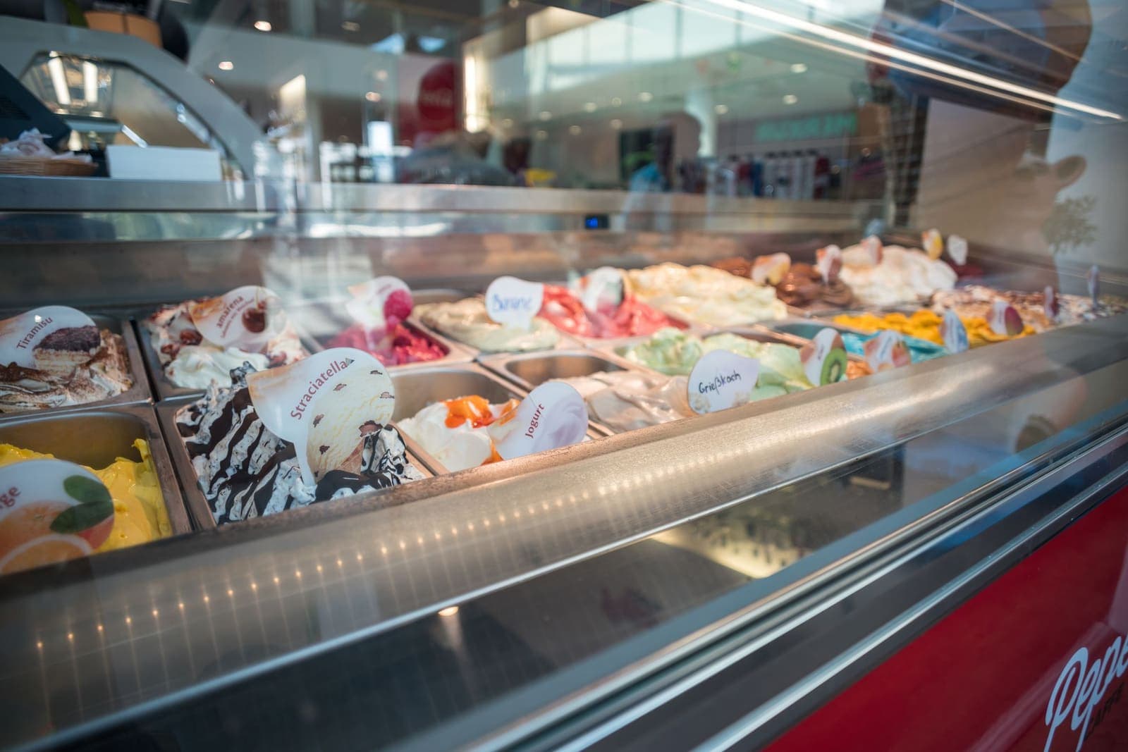 Vitrine de gelato artesanal com sabores expostos em uma sorveteria